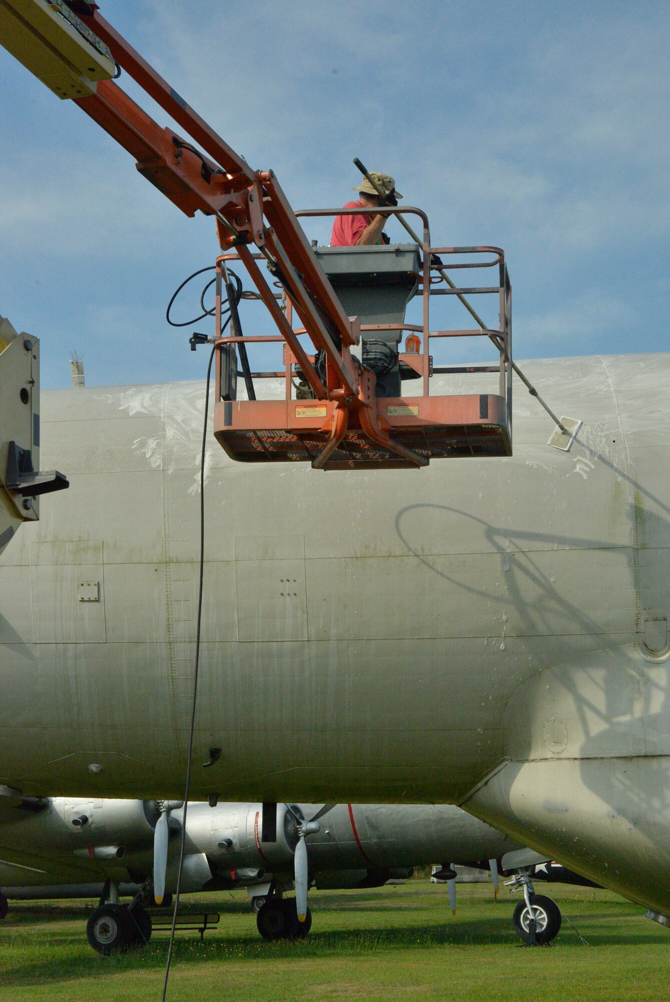 Erwin Ross, exhibit specialist, uses a scrub brush to get the grime off of a C-121 Constellation. (U.S. Air Force photo by Ed Aspera)