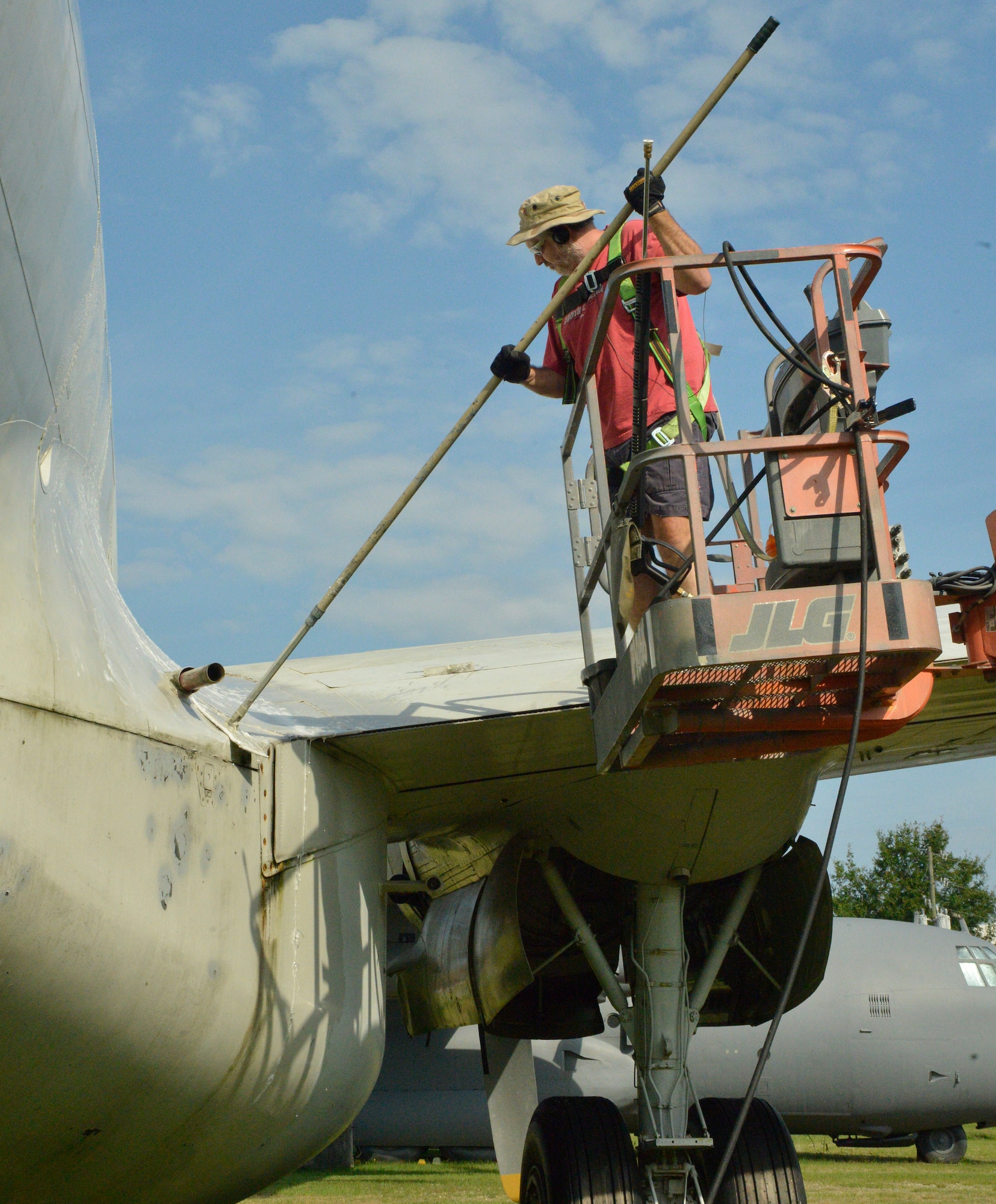 Erwin Ross, exhibit specialist, uses a scrub brush to get the grime off of a C-121 Constellation. (U.S. Air Force photo by Ed Aspera)