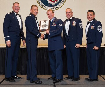 Col. Robert Lyman (left), Joint Base Charleston commander, Col. John Lamontagne, 437th Airlift Wing commander, Chief Master Sgt. Kristopher Berg, 437th Airlift Wing command chief, Chief Master Sgt. Chad Balance, 628th Medical Group superintendent, congratulate Senior Airman Joshua Orphan, from the 437th Aerial Port Squadron, for receiving the John L. Levitow Award during an Airman Leadership School Graduation ceremony June 23, 2016, at Joint Base Charleston, S.C. The Levitow award is the highest honor bestowed during ALS and is awarded to the Airman who displays the highest level of leadership qualities. (U.S. Air Force photo/Airman 1st Class Kevin West)
