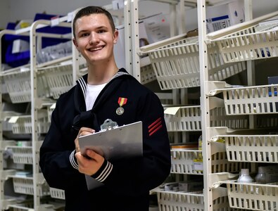 Seaman Kellen Kloss, a Naval Health Clinic Charleston dental supply clerk, smiles whilechecking inventory in the dental supply room at the Joint Base Charleston-Weapons Station NHCC, June 17, 2016. Kloss plans to spend the 4th of July with his shipmates on Patriot’s Point watching fireworks over the Cooper River. Kloss believes the holiday is the ultimate celebration for all Americans and it unifies Americans who come from diverse backgrounds. (U.S. Air Force Photo/Airman Megan Munoz)