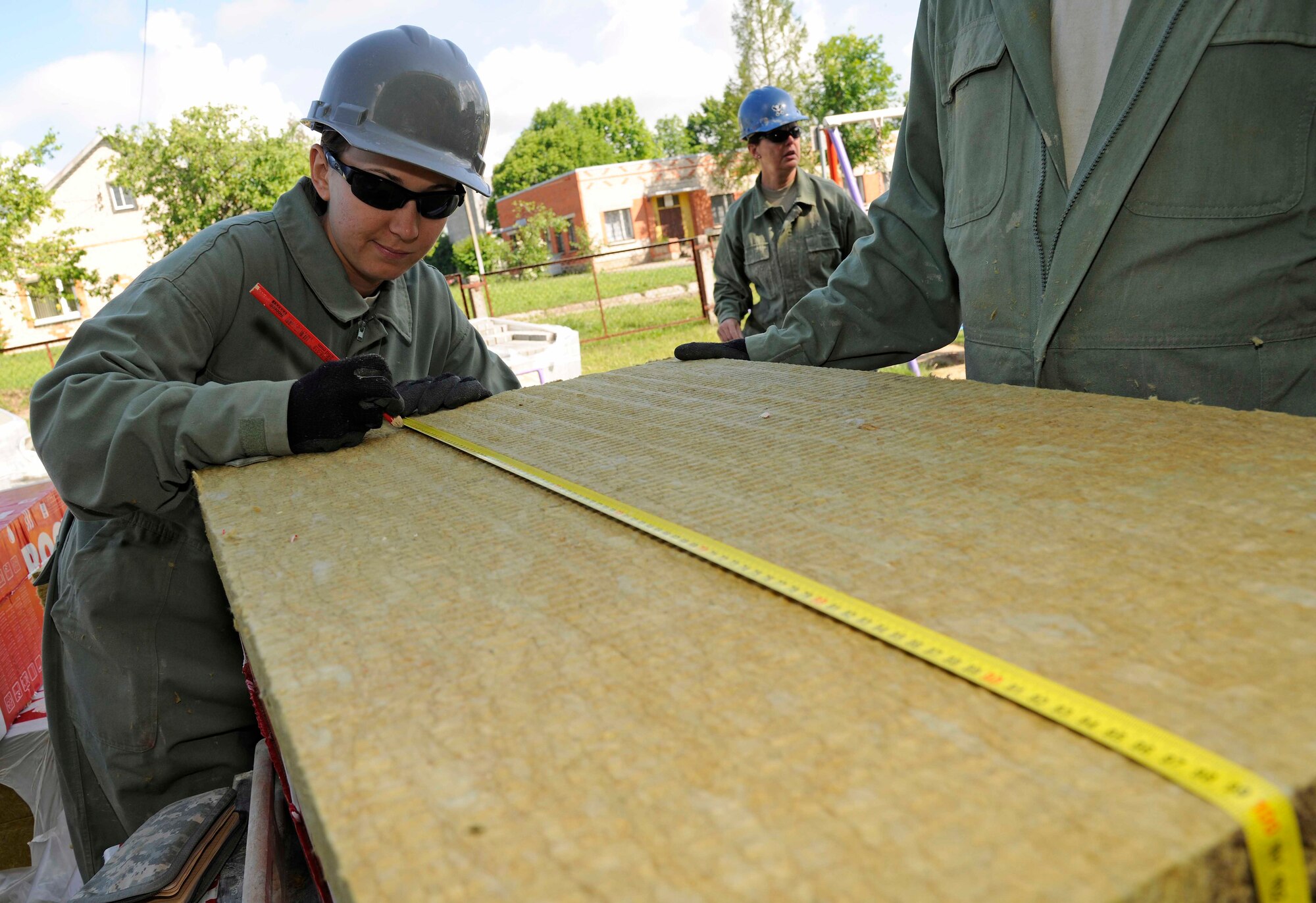 Staff Sgt. Amanda Turnwald, 127th Civil Engineering Squadron engineering assistant, marks a measurement on a piece of rock wool insulation at a kindergarten in Silmala, Latvia on June 23, 2016. The school is currently undergoing a Humanitarian-civic assistance project to provide the school with up to date renovations. (U.S. Air National Guard photo by Senior Airman Ryan Zeski)