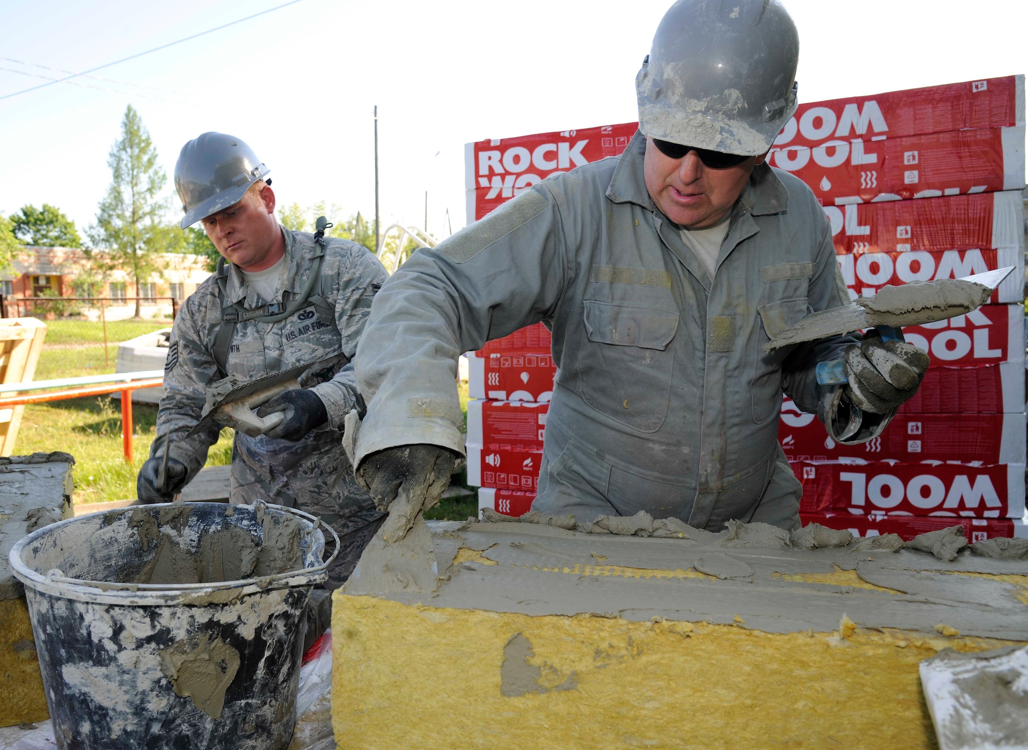 Staff Sgt. John Martin, 127th Civil Engineering Squadron pavements and construction supervisor and Tech. Sgt. Ed Hirth, 127th CES firefighter, apply a mud adhesive to rock wool insulation at a kindergarten in Silmala, Latvia on June 23, 2016. The school is currently undergoing a Humanitarian-civic assistance project to provide the school with up to date renovations. (U.S. Air National Guard photo by Senior Airman Ryan Zeski)