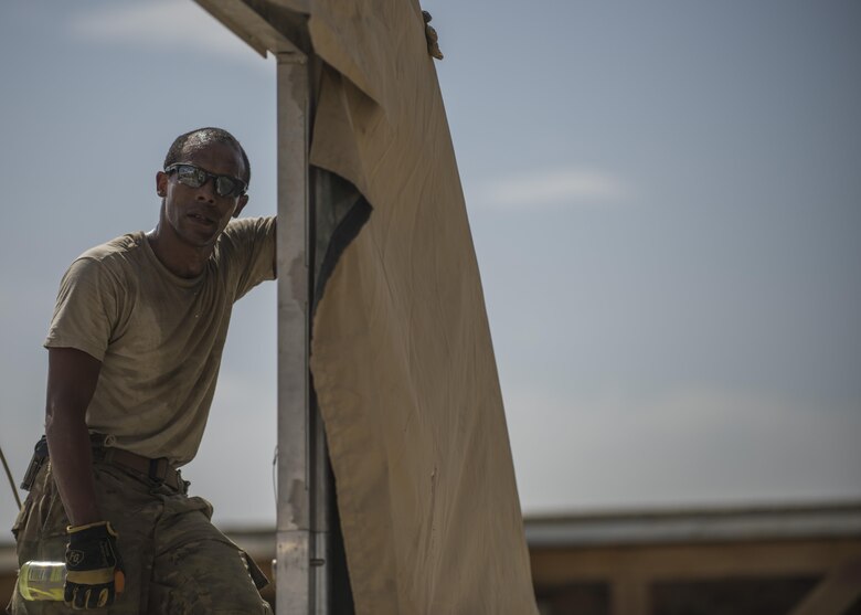 An Airman from the 455th Expeditionary Civil Engineer Squadron leans against a tent they are building, June 25, 2016, Bagram Airfield, Afghanistan. The new tent will be the new location for the heating, ventilation, and air conditioning and power production shops. (U.S. Air Force photo by Senior Airman Justyn M. Freeman)