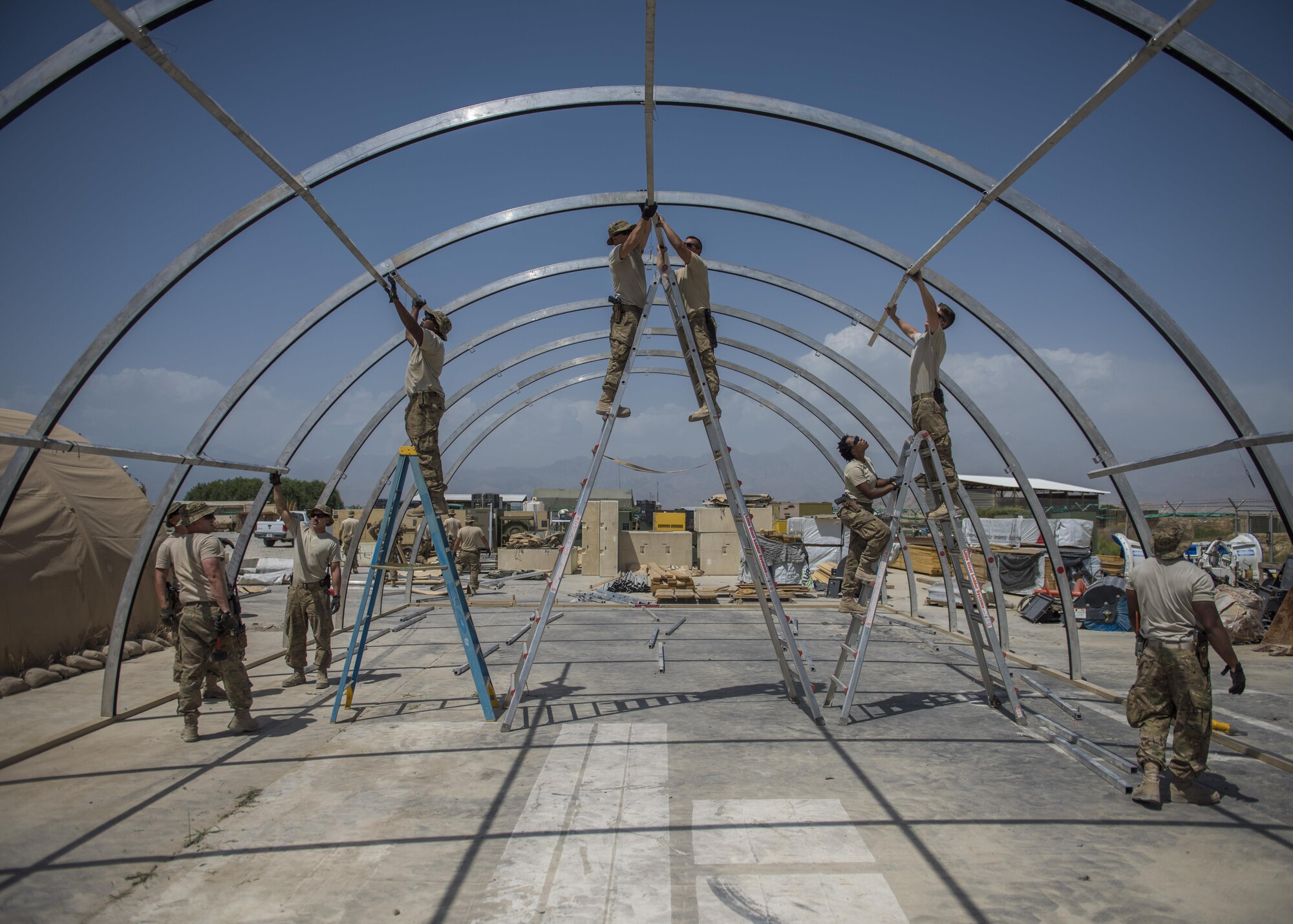Airmen from the 455th Expeditionary Civil Engineer Squadron construct a new tent, June 25, 2016, Bagram Airfield, Afghanistan. All flights within the 455th ECES, including structures, dirt boys, and electrical, came together to build a new tent to relocate the power production and heating, ventilation, and air conditioning shops. (U.S. Air Force photo by Senior Airman Justyn M. Freeman)
