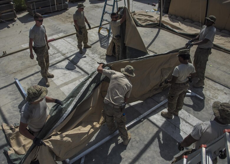 Airman from the 455th Expeditionary Civil Engineer Squadron work together to put fabric on a tent skeleton, June 25, 2016, Bagram Airfield, Afghanistan. All flights within the 455th ECES, including structures, dirt boys, and electrical, came together to build a new tent to relocate the power production and heating, ventilation, and air conditioning shops. (U.S. Air Force photo by Senior Airman Justyn M. Freeman)
