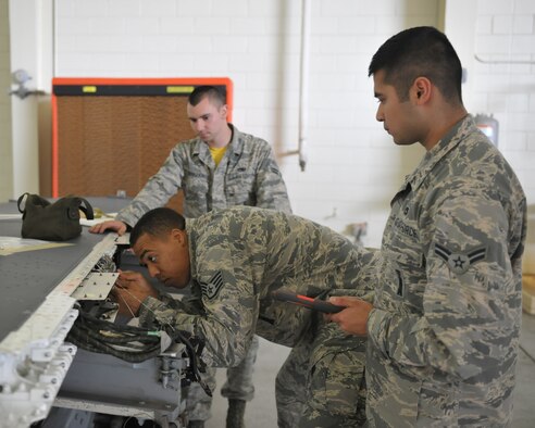 Staff Sgt. Dwight Hunter, 8th Aircraft Maintenance Squadron Aircraft Armament Systems team chief, verifies connectors for a protective covering and proper routing of wires inside a wing as team members observe June 24, 2016 at Kunsan Air Base, Republic of Korea. Hunter and his team are working with other maintenance Air Force Specialty Codes on a simultaneous double wing replacement. (U.S. Air Force photo/Master Sgt. David Miller)