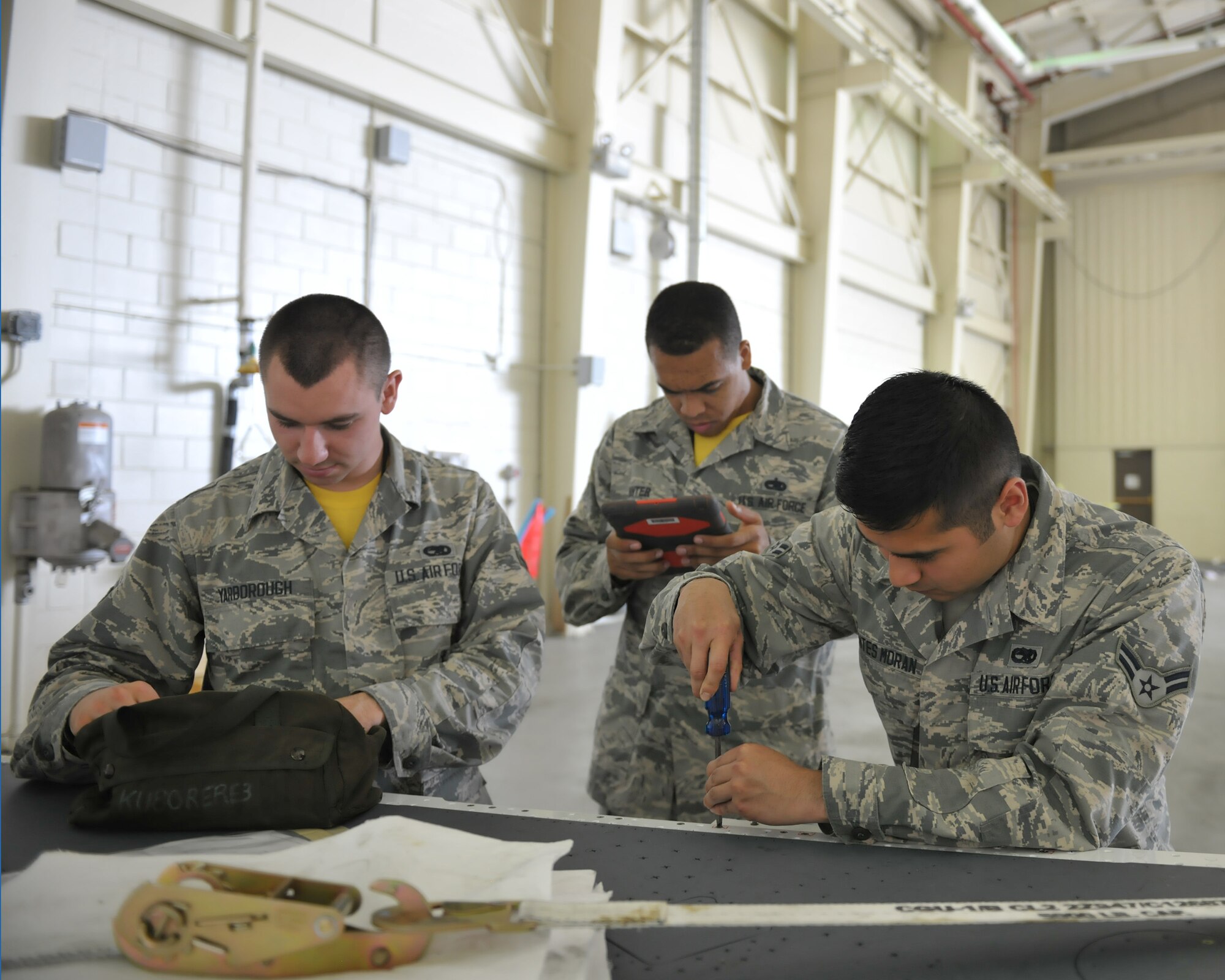 Airman 1st Class Ismael Fuentes Moran, 8th Aircraft Maintenance Squadron Aircraft Armament Systems craftsman, installs a support bracket for a wing wiring harness as crew member Airman 1st Class Carson Yarborough and team chief Staff Sgt. Dwight  on June 24, 2016 at Kunsan Air Base, Republic of Korea. The team are working with other maintenance Air Force Specialty Codes on a simultaneous double wing replacement. (U.S. Air Force photo/Master Sgt. David Miller)