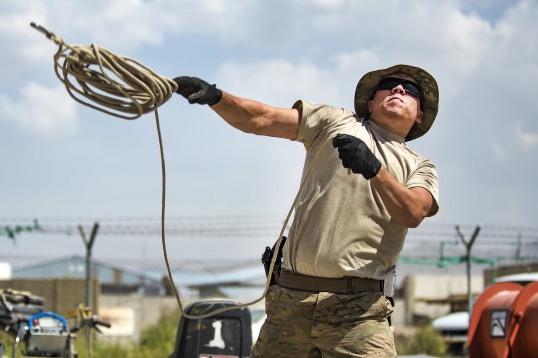 Air Force Senior Airman Eric Woolston throws a rope while helping to construct a tent at Bagram Airfield, Afghanistan, June 25, 2016. Woolston is a structural journeyman assigned to the 455th Expeditionary Civil Engineer Squadron. The new tent will house the power production and heating, ventilation and air conditioning shops. Air Force photo by Senior Airman Justyn M. Freeman
