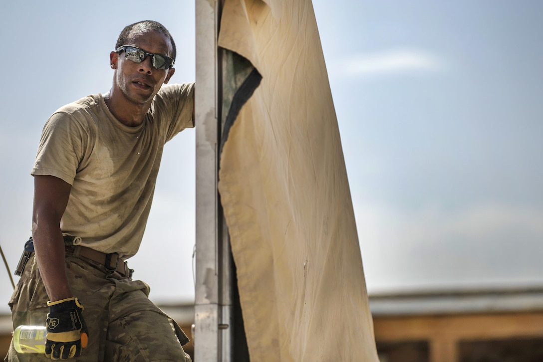 An airman takes a break while helping to build a tent at Bagram Airfield, Afghanistan, June 25, 2016. Air Force photo by Senior Airman Justyn M. Freeman