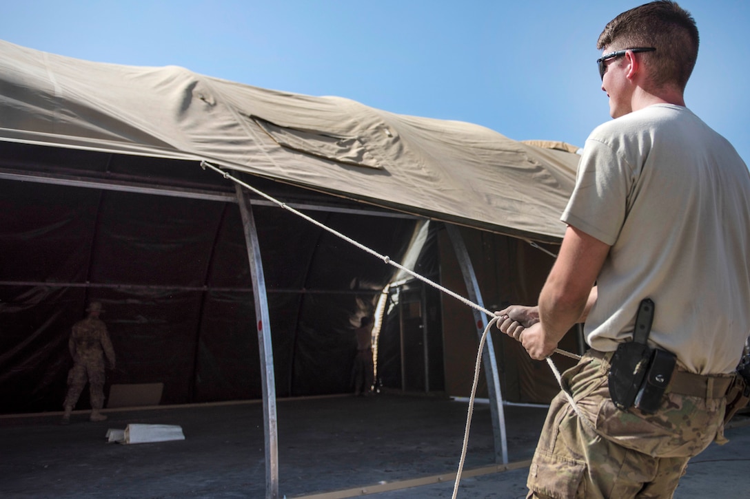 Air Force Senior Airman Jonathan Brooks pulls a tent cover down at Bagram Airfield, Afghanistan, June 25, 2016. Brooks is a structural journeyman assigned to the 455th Expeditionary Civil Engineer Squadron. Air Force photo by Senior Airman Justyn M. Freeman