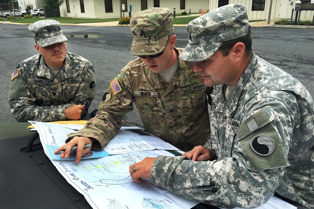 From left, Army Spc. Rimel, Sgt. White and Sgt. Dameron discuss  safe routes after picking up stranded residents during severe flooding in Allegheny County, Va., June 24, 2016. The soldiers are assigned to the Virginia National Guard’s 116th Infantry Brigade Combat Team. Army National Guard photo by Alfred Puryear
