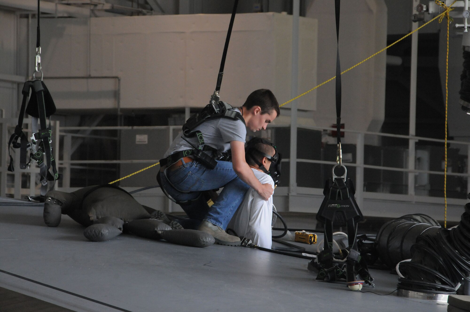 Senior Airman Barrett Lowry, a fuel systems mechanic with the 445th Aircraft Maintenance Squadron, makes a radio call to initiate base emergency responders to come to his location during the annual Confined Space Emergency Extraction Exercise at Wright-Patterson Air Force Base, Ohio June 21, 2016.  The exercise scenario was conducted to practice confined space self-rescue procedures in the extraction of an incapacitated airman from a long range fuel tank behind the #2 engine of a C-17 Globemaster III. (U.S. Air Force Photo by Tech. Sgt. Anthony G. Springer)
