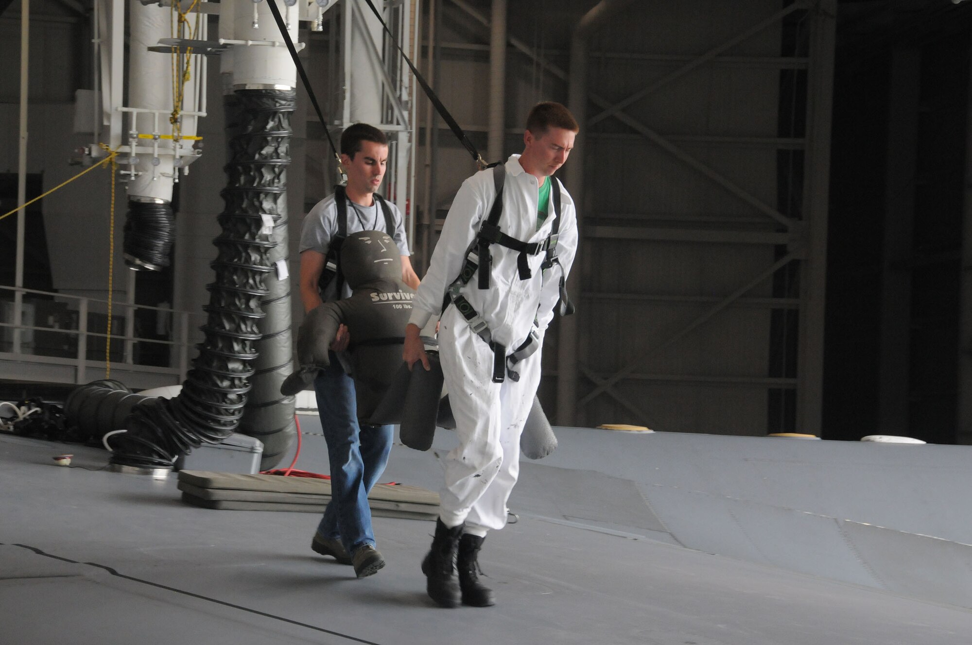 Tech. Sgt. Jared Rucker and Senior Airman Barrett Lowry, both fuel systems mechanics with the 445th Aircraft Maintenance Squadron, carry a simulated victim across the port side wing of a C-17 Globemaster III during the annual Confined Space Emergency Extraction Exercise at Wright-Patterson Air Force Base, Ohio June 21, 2016.  The exercise scenario was conducted to practice confined space self-rescue procedures in the extraction of an incapacitated airman from a long range fuel tank behind the #2 engine of the aircraft. (U.S. Air Force Photo/Tech. Sgt. Anthony G. Springer)