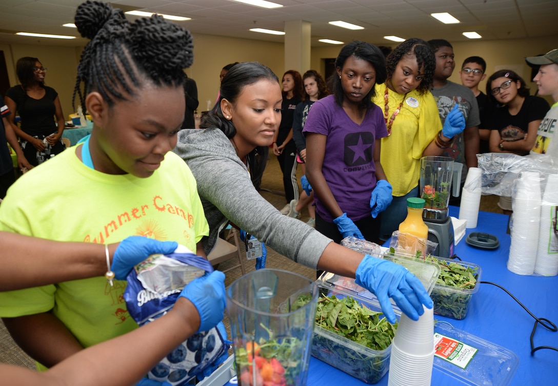 Twenty-seven teens attend a five-day summer program at Marine Corps Logistics Base Albany, recently. In one activity, Tiara Noel (second from left), nurse, Child Development Center, MCLB Albany, assisted participating teens in preparing fruit and veggie smoothies as part of their learning on developing a healthier lifestyle through healthy eating. Teen C.A.R.R.O.L.L. University facilitators taught youth skills designed to help shape their day-to-day activities as well as their future choices and career goals.