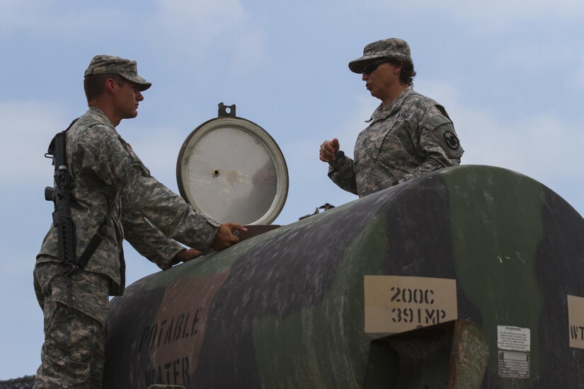 Chief Warrant Officer 3 Kim Shiner, a food advisor with the U.S. Army Reserve Command and native of Van Meter, Iowa, inspects a portable water tank with Spc. Richard Kirsh, a U.S. Army Reserve preventive medicine specialist with the 391st Military Police Battalion from Columbus, Ohio, during the Philip A. Connelly Competition at Camp Atterbury, Indiana, June 23. The 391st is representing the 200th MP Command in the competition, part of a training program designed to improve professionalism and recognize excellence, which augments the quality of food and food service within the Army. The top four food service teams will continue to the U.S. Army Reserve level competition. (U.S. Army photo by Sgt. Audrey Hayes)
