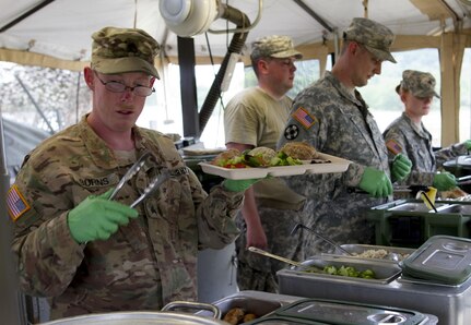 Sgt. Justin Burns, a U.S. Army Reserve culinary specialist from Columbus, Ohio, with the 391st Military Police Battalion, serves lunch to Soldiers during the Philip A. Connelly Competition at Camp Atterbury, Indiana, June 23. The 391st is representing the 200th MP Command in the competition, part of a training program designed to improve professionalism and recognize excellence, which augments the quality of food and food service within the Army. The top four food service teams will continue to the U.S. Army Reserve level competition. (U.S. Army photo by Sgt. Audrey Hayes)