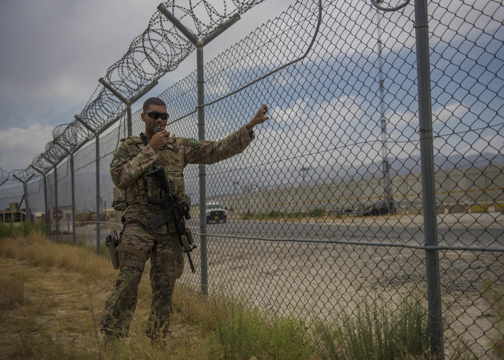 Staff Sgt. Gary Allsbrook, 455th Expeditionary Security Forces Squadron quick reaction force, moves the fence to check the tactical automated security system (TASS), June 27, 2016, Bagram Airfield, Afghanistan. Allsbrook and other security forces Airmen conduct daily checks on the TASS systems to assure it operates properly. (U.S. Air Force photo by Senior Airman Justyn M. Freeman)