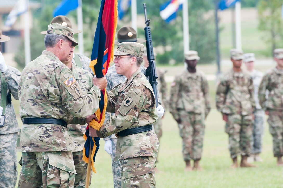 Maj. Gen. Mark McQueen, commander of the 108th Training Division (Initial Entry Training), takes the colors from Brig. Gen. Tammy Smith, commander of the 98th Training Division (IET), during a Relinquishment of Command Ceremony at Brave Rifles Parade Field on June 26. Smith, who has been in command of the Army Reserve division headquartered at Fort Benning since November 2015, will move to Korea to become the Deputy Commanding General of Sustainment for Eighth Army.