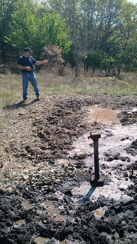 Jason Person, environmental specialist for the U.S. Army Corps of Engineers Tulsa District, looks over a salt water leak at an abandoned well on the edge of Corps land near Birch Lake, May 10, 2016. Person is the lone environmental specialist for Tulsa Districts Northern Area, a huge area of land covering approximately 15,000 square miles and 13 USACE projects. (USACE photo by Thomas Mills/Released)