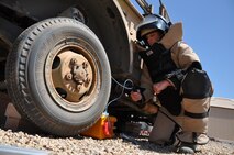 Senior Airman Logan Avery, 56th Civil Engineer Squadron Explosive Ordnance Disposal team leader, renders safe a simulated homemade explosive June 24 at Luke Air Force Base. Avery is wearing an EOD 9 Bomb Suit and Helmet for
protection against directional fragments.
