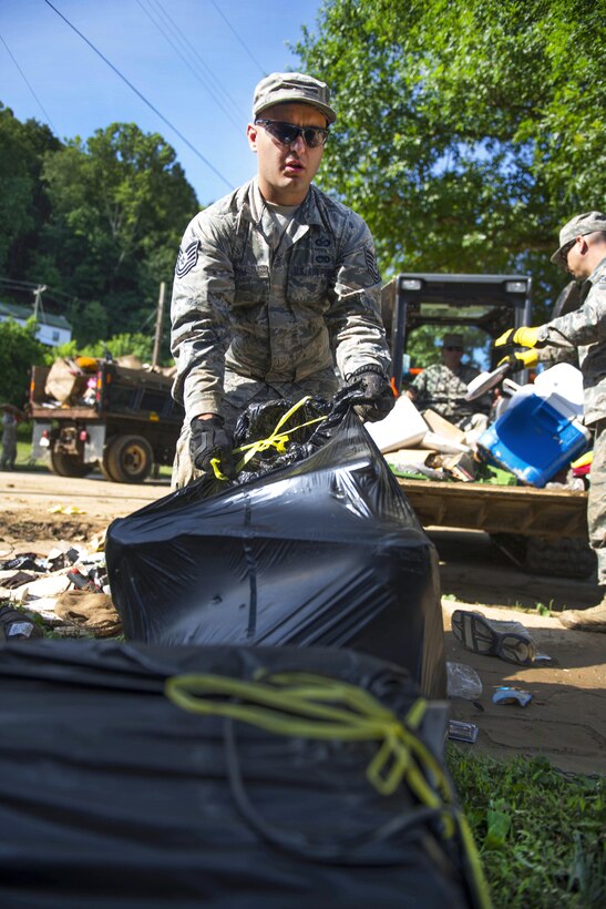 Air Force Tech. Sgt. Brian Grim picks up debris in Clendenin, W.Va., June 26, 2016, while assisting with flood response efforts. Grim is assigned to the West Virginia Air National Guard’s 167th Airlift Wing. Air National Guard photo by Tech. Sgt. De-Juan Haley