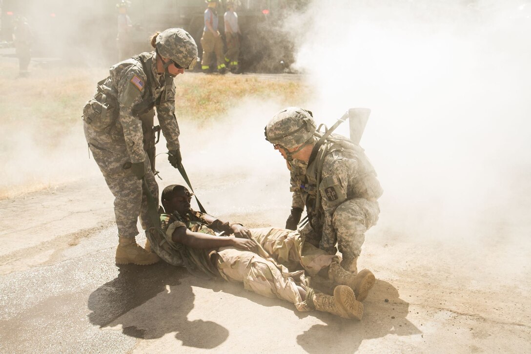 US Army Soldiers from the 441st Medical Company drag an unresponsive Pfc. Kenneth Roper away from the site of a simulated helicopter crash. Pfc. Roper was suffering from a head wound (simulated) resulting from the crash which took place on May 9, 2016 at Fort Hunter Liggett, Calif. as a part of the 91st Training Division's WAREX 2016. This realistic training with live role playing casualties adds an important level of realism for the Soldiers. (U.S. Army photos by 1LT Kevin Braafladt 91st Training Division Public Affairs/Released)  #91TD2016WAREX