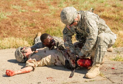 A U.S. Army Soldier with the 441st Medical Company, treats a simulated wound at the scene of a helicopter crash while a "friend" pleads to help the wounded soldier during the 91st Training Division's WAREX taking place at Fort Hunter Liggett, Calif. on May 9, 2016. This realistic training with live role playing casualties adds an important level of realism for the responding Medical Soldiers. (U.S. Army photos by 1LT Kevin Braafladt 91st Training Division Public Affairs/Released)  #91TD2016WAREX