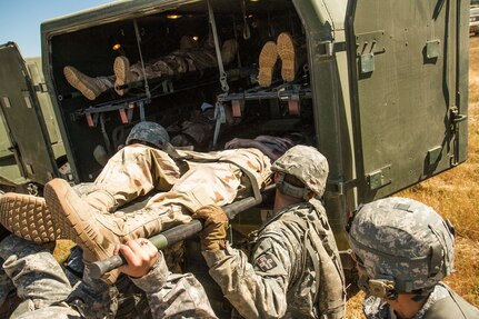 Soldiers from the 441st Medical Company load simulated casualties into an ambulance at the site of a simulated helicopter crash on May 9, 2016 at Fort Hunter Liggett, Calif. as a part of the 91st Training Division's WAREX 2016. This realistic training with live role playing casualties adds an important level of realism for the Soldiers. (U.S. Army photos by 1LT Kevin Braafladt 91st Training Division Public Affairs/Released)  #91TD2016WAREX