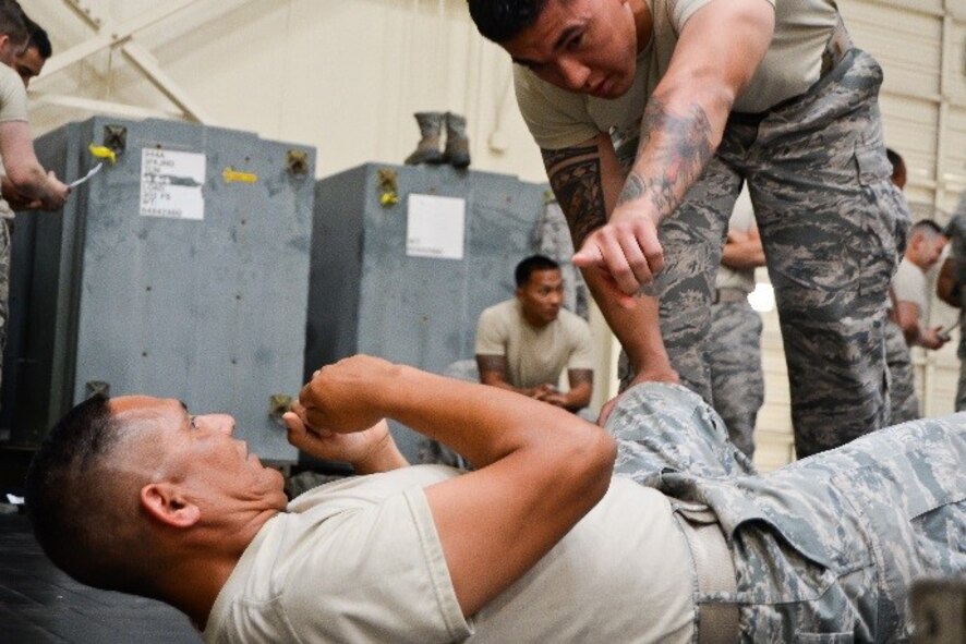 Tech. Sgt. Richard Timney (standing) offers helpful tips to Tech. Sgt. Manuel Medina, both 944th Security Forces Squadron members, for mastering the shrimping technique during a combatives course June 4, 2016 at Luke Air Force Base, Ariz. Techniques like shrimping enable security forces members to evade attackers and help them gain the upper hand in combat. (U.S. Air Force photo by Staff Sgt. Nestor Cruz)
