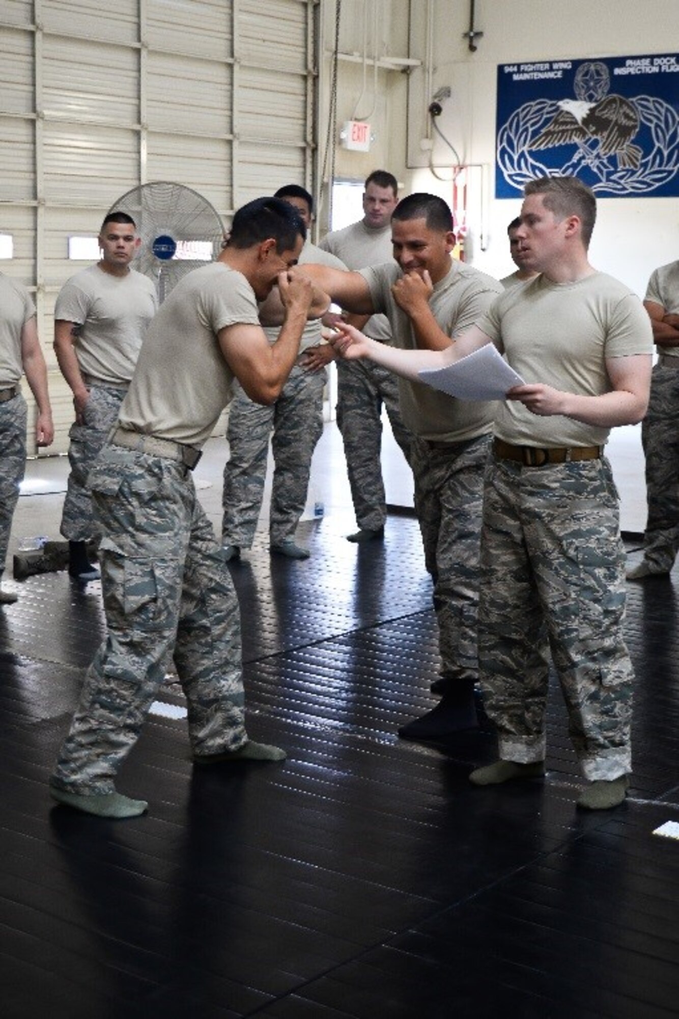 Senior Airman Daniel Myers, 944th Security Forces Squadron, guides fellow security forces members in mastering a defensive technique during a combatives course June 4, 2016 inside Hangar 999 at Luke Air Force Base, Ariz. Myers is a certified combatives instructor for the course, now an annual requirement for security forces Airmen. (U.S. Air Force photo by Staff Sgt. Nestor Cruz)