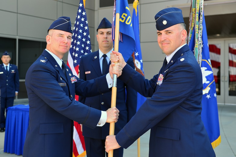 Col. Dennis Bythewood, then 50th Operations Group commander, presents the guidon to Lt. Col. Joshua Brooks during the 3rd Space Operations Squadron change of command at Schriever Air Force Base, Colorado, Monday, June 20, 2016. Brooks assumed 3 SOPS command from Lt. Col. Chris Todd. (U.S. Air Force photo/Dennis Rogers)