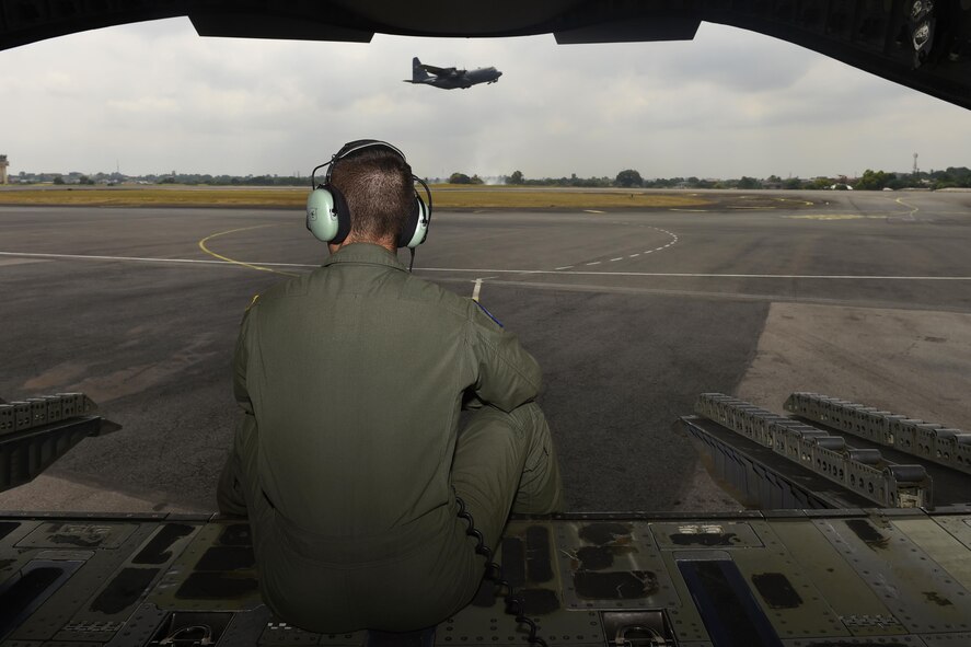 Senior Airman William Buckles, 7th Airlift Squadron C-17 Globemaster III loadmaster, watches a C-130 Hercules take off from Libreville, Gabon Africa June 22, 2016, during exercise Central Accord 2016. U.S. Army Africa's exercise Central Accord 2016 is an annual, combined, joint military exercise that brings together partner nations to practice and demonstrate proficiency in conducting peacekeeping operation. (U.S. Air Force photo/Tech. Sgt. Tim Chacon)