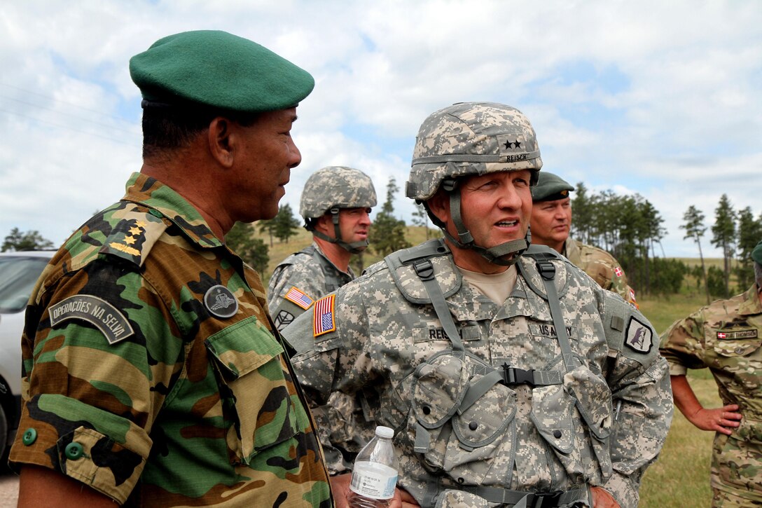 U.S. Army Maj. Gen. Tim Reisch, adjutant general of the South Dakota National Guard, and Col. Adolf Jardim, deputy commander of the Suriname Defense Force, observe the urban patrol training lane during the Golden Coyote training exercise at West Camp Rapid, Rapid City, S.D. June 20, 2016. 