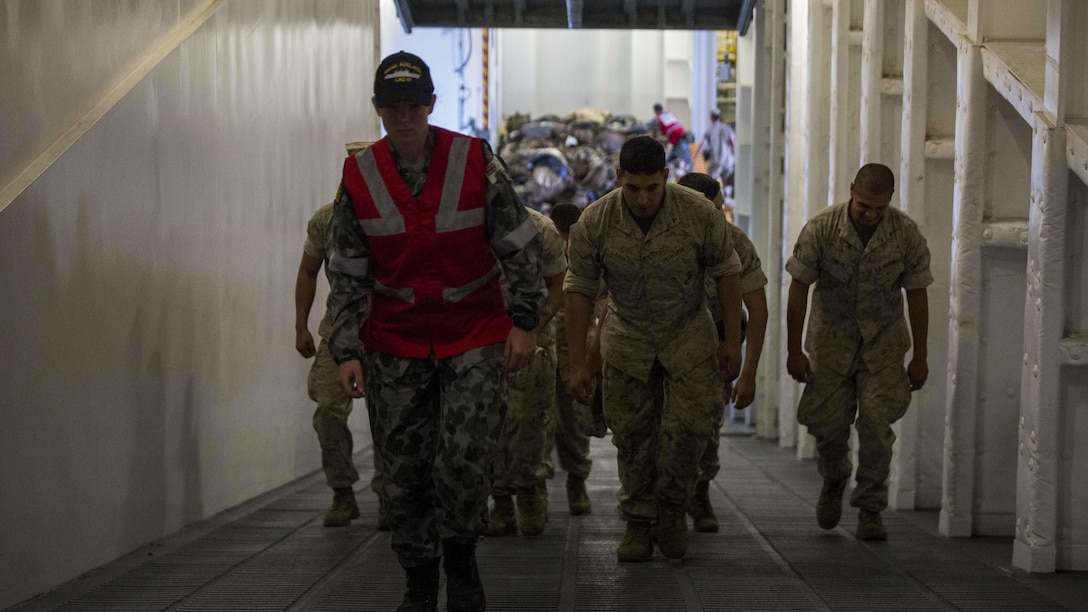 An Australian sailor guides U.S. Marines to an upper deck aboard the HMAS Adelaide at Port of Brisbane, Queensland, Australia, June 16, 2016. This marks the first time Marines and sailors from Marine Rotational Force - Darwin have embarked in such numbers on an Australian HMAS. This opportunity allows for MRF-D to expand the partnership capabilities with our Australian allies. The Marines are with 1st Battalion, 1st Marine Regiment, MRF-D, and the Australians are with HMAS Adelaide. 