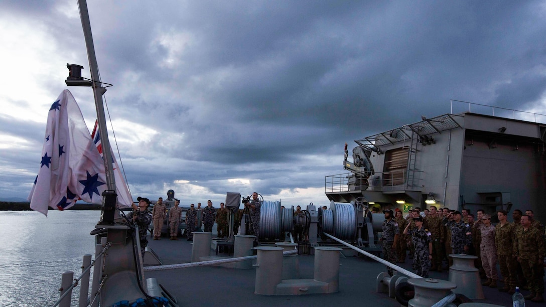 U.S. Marines, Australian soldiers and Australian sailors stand at attention for the lowering of the Australian flag aboard the HMAS Adelaide at Port of Brisbane, Queensland, Australia, June 16, 2016. This marks the first time Marines and sailors from Marine Rotational Force - Darwin have embarked in such numbers on an Australian HMAS. This opportunity allows for MRF-D to expand the partnership capabilities with our Australian allies. The Marines are with 1st Battalion, 1st Marine Regiment, MRF-D. 