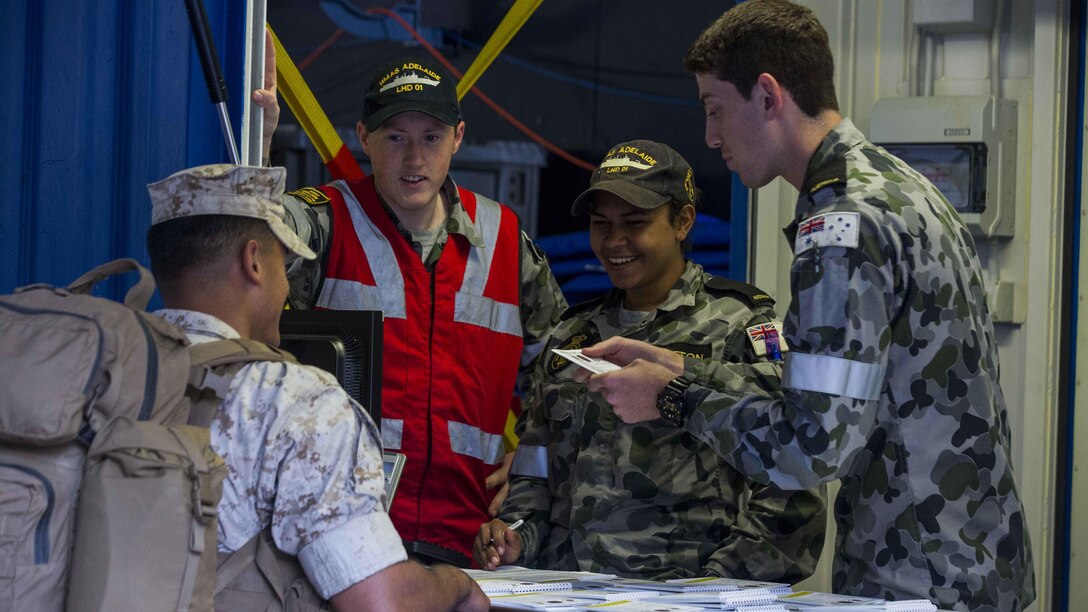 U.S. Marines receive a welcome aboard booklet upon arrival to the HMAS Adelaide at Port of Brisbane, Queensland, Australia, June 16, 2016. This marks the first time Marines and sailors from Marine Rotational Force - Darwin have embarked in such numbers on an Australian HMAS. This opportunity allows for MRF-D to expand the partnership capabilities with our Australian allies. The Marines are with 1st Battalion, 1st Marine Regiment, MRF-D, and the Australians are with HMAS Adelaide. 