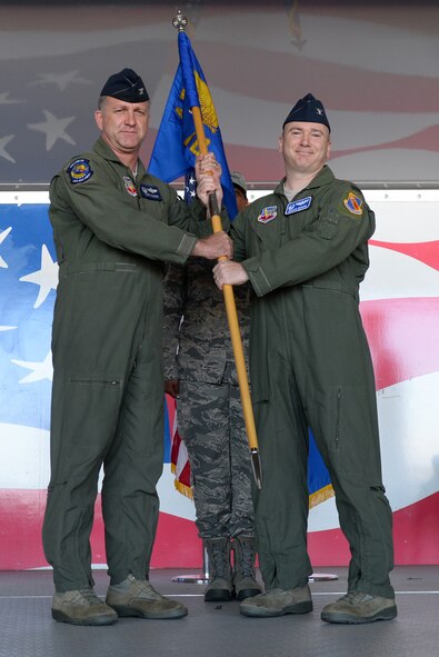 Col. Mark Slocum, 4th Fighter Wing commander, passes the guidon to Col. Richard Dickens, incoming 4th Operations Group commander, June 20, 2016, at Seymour Johnson Air Force Base, North Carolina. Dickens is a senior pilot who has accumulated more than 2,400 flight hours in the F-15E Strike Eagle, including 688 combat hours. (U.S. Air Force photo by Airman 1st Class Ashley Williamson)