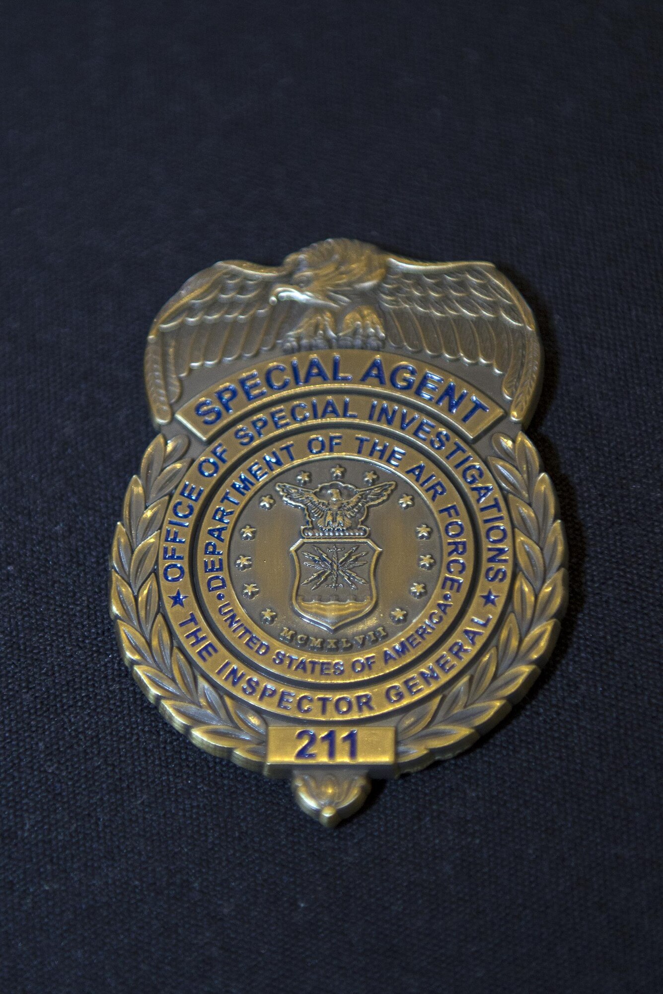 An Air Force Office of Special Investigations Detachment 211 coin rests on display during a luncheon, June 27, 2016, at Moody Air Force Base, Ga. The OSI has been the Air Force’s major investigative service since its creation on Aug. 1, 1948. (U.S. Air Force photo by Airman 1st Class Greg Nash/Released)