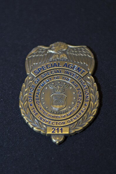 An Air Force Office of Special Investigations Detachment 211 coin rests on display during a luncheon, June 27, 2016, at Moody Air Force Base, Ga. The OSI has been the Air Force’s major investigative service since its creation on Aug. 1, 1948. (U.S. Air Force photo by Airman 1st Class Greg Nash/Released)