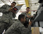 KUNSAN AIR BASE, Republic of Korea (June 24, 2016) - Staff Sgt. Dwight Hunter, 8th Aircraft Maintenance Squadron Aircraft Armament Systems team chief, oversees Airman 1st Class Ismael Fuentes Moran and Airman 1st Class Carson Yarborough, 8th AMXS Aircraft Armament Systems craftsmen, as they install a jettison release interface unit at Kunsan Air Base.  Hunter and his team are working with other maintenance Air Force Specialty Codes on a simultaneous double wing replacement. 