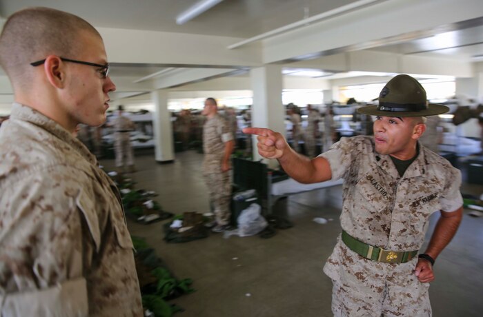 Sergeant Carlos Castro, drill instructor, Charlie Company, 1st Recruit Training Battalion, corrects a recruit for not following directions during pick up at Marine Corps Recruit Depot San Diego, June 24. Pick up is the first encounter the recruits have with the drill instructors who are charged with the responsibility of transforming the recruits into basically-trained Marines. Annually, more than 17,000 males recruited from the Western Recruiting Region are trained at MCRD San Diego. Charlie Company is scheduled to graduate Sept. 16.