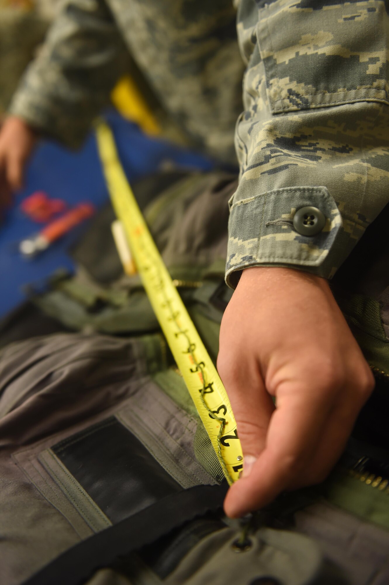 Senior Airman Matthew, a 49th Operations Support Squadron aircrew flight equipment technician, measures thread needed to repair a G-Suit for a pilot at Holloman Air Force Base, N.M., June 20. AFE specialists are responsible for ensuring that all flight and safety equipment is in perfect working order. (Last names are being withheld due to operational requirements. U.S. Air Force photo by Staff Sgt. Eboni Prince)