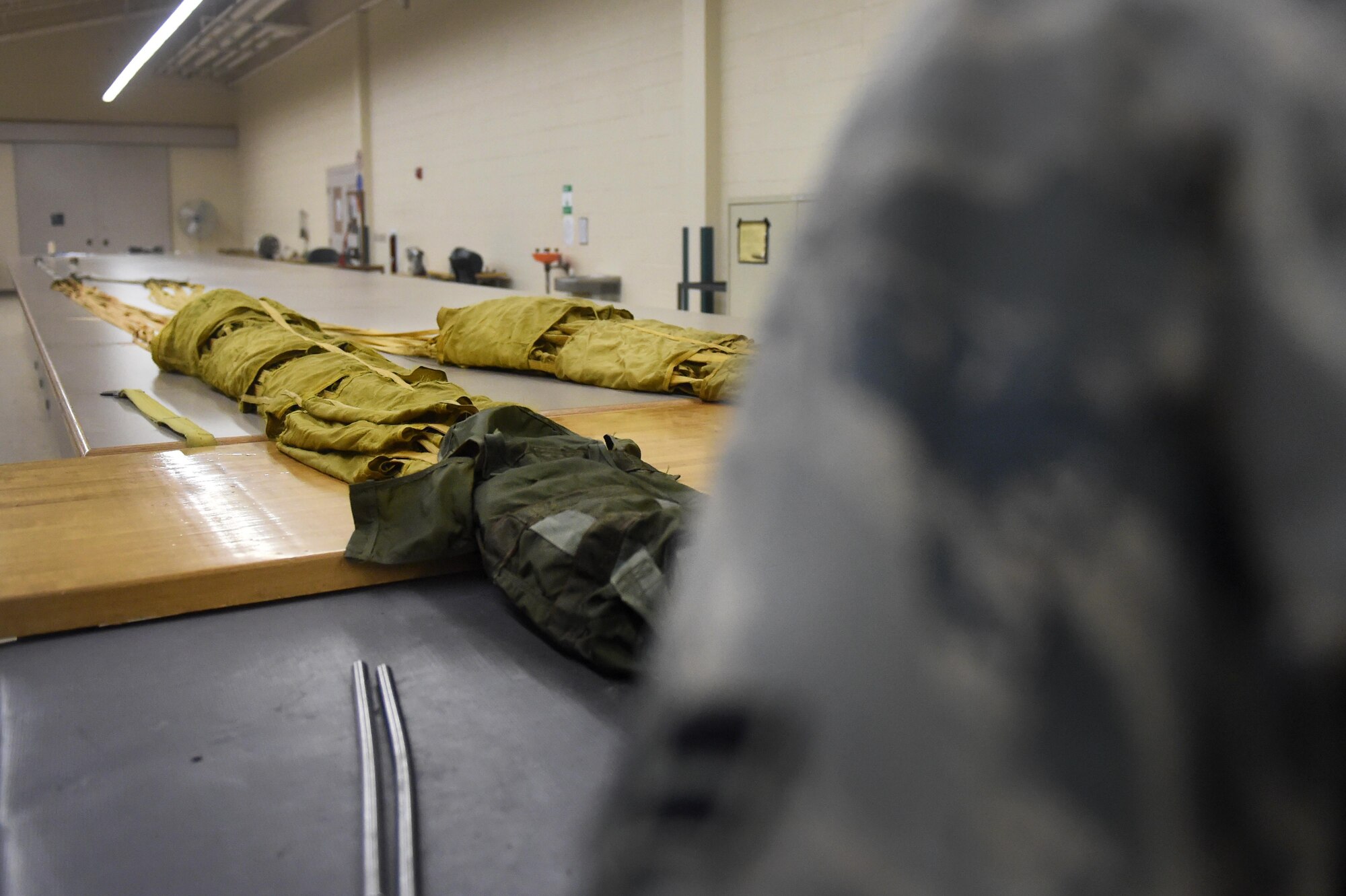 Airman 1st Class Dondrel, a 49th Operations Support Squadron aircrew flight equipment technician, prepares to pack a parachute at Holloman Air Force Base, N.M., July 21. AFE personnel issue, fit, repair, and maintain equipment such as parachutes, helmets, and oxygen equipment. (Last names are being withheld due to operational requirements. U.S. Air Force photo by Staff Sgt. Eboni Prince)