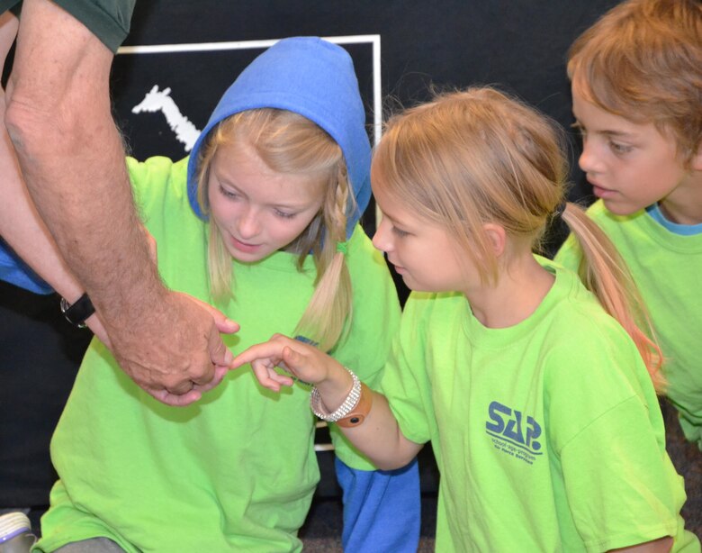 Kiera VanHorn, Arianna Carroll and Peter Ghigleri examine a cockroach during a presentation from the Cheyenne Mountain Zoo Zoomobile at the Schriever Child Development Center, Monday, June 27, 2016. In addition to the insect, the Zoomobile introduced youth to a tarantula, skink and albino rabbit. (U.S. Air Force photo/Brian Hagberg)