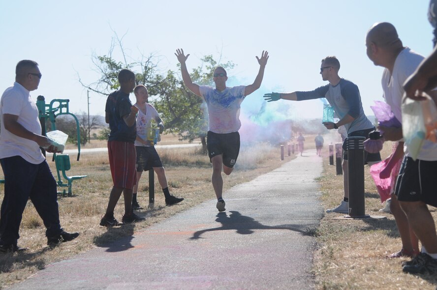 Master Sgt. Daniel, from the 548th Operations Support Squadron, gets doused with colored powder while finishing the annual 5K color run at Beale Air Force Base, June 24, 2016. This year Beale was able to celebrate the LGBT community as DoD has officially made June LGBT Pride Month. (U.S. Air Force photo by Airman 1st Class Jessica B. Nelson)