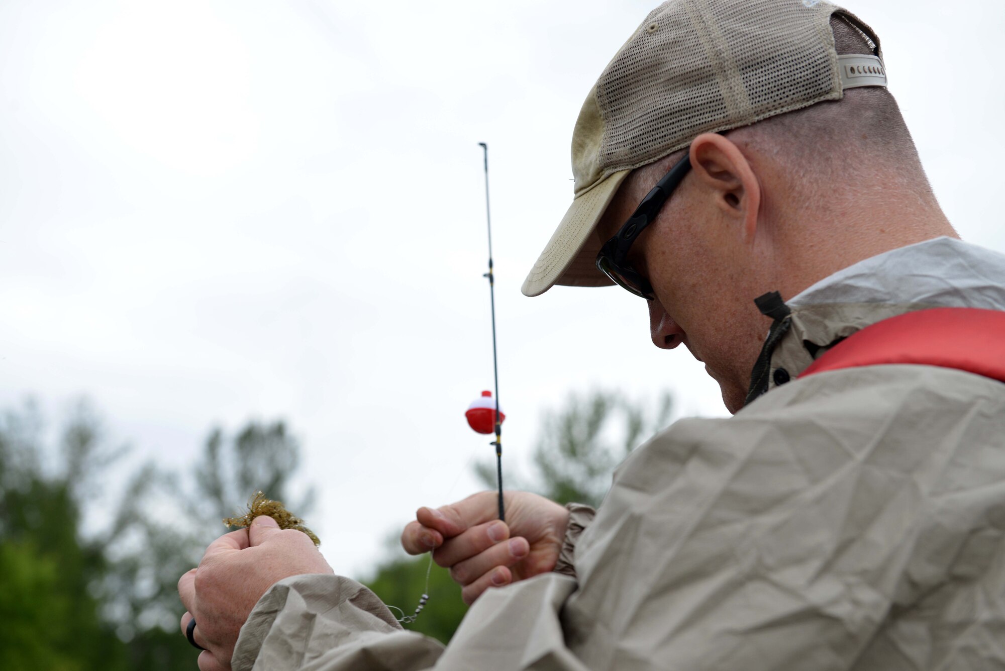 Joe Palmer, a Navy reservist, picks off a bit of moss, from his hook at Otter Lake at Joint Base Elmendorf-Richardson, Alaska, June 23, 2016. This was the first Introduction to Fishing class hosted on JBER. (U.S. Air Force photo by Airman 1st Class Javier Alvarez)