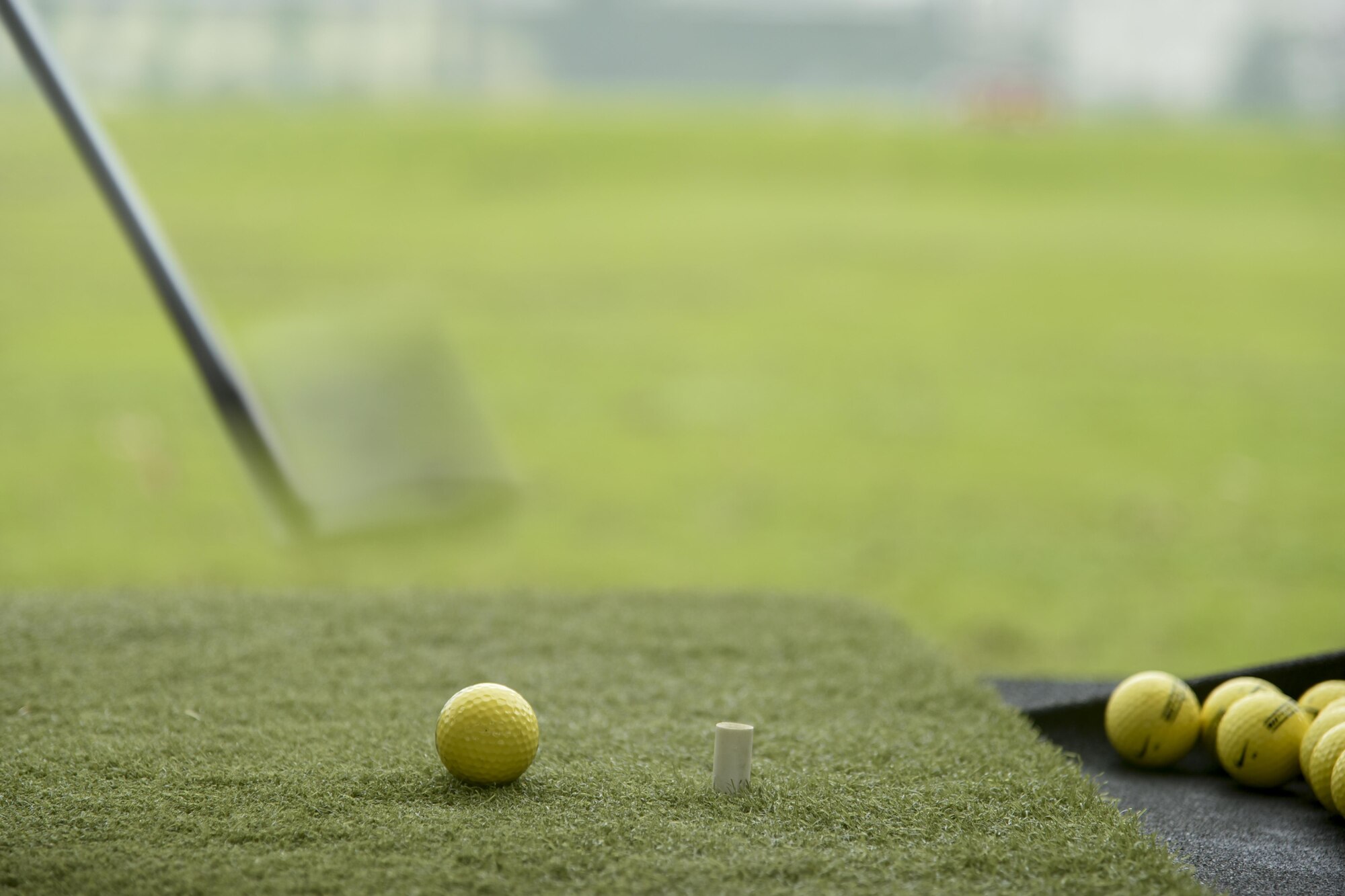 A golf club swings past a ball as it sits on astroturf during the Ladies Professional Golf Association golf clinic at Yokota Air Base, Japan, June 23, 2016. Professional golfers Jenny Gleason and Amy Read came to Yokota and hosted a free golf clinic for community members. (U.S. Air Force photo by Staff Sgt. Michael Washburn/Released)