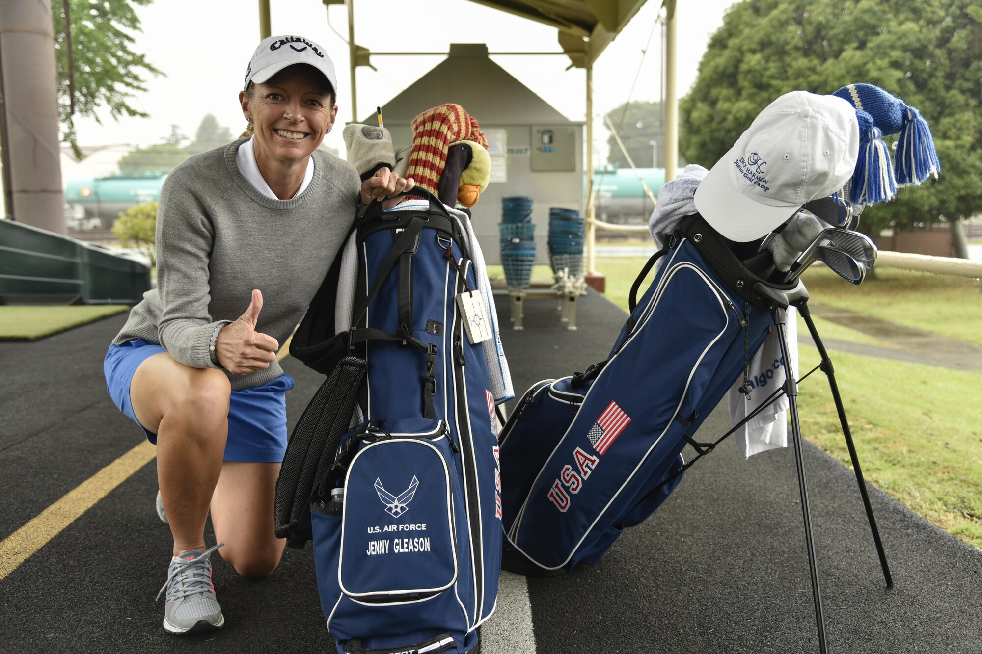 Jenny Gleason, professional golfer, kneels near her bag during the Ladies Professional Golf Association golf clinic at Yokota Air Base, Japan, June 22, 2016. Professional golfers Jenny Gleason and Amy Read came to Yokota and hosted a free golf clinic for community members. (U.S. Air Force photo by Staff Sgt. Michael Washburn/Released)