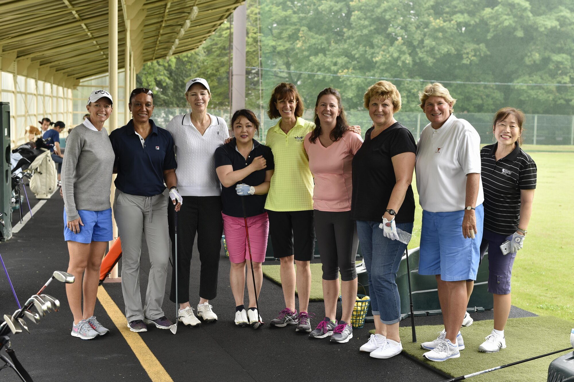 Team Yokota members and professional golfers Jenny Gleason (left) and Amy Reid (second from right) take a group photo during the Ladies Professional Golf Association golf clinic at Yokota Air Base, Japan, June 22, 2016. The clinic was held from June 22 to the 25th and free to the Yokota community. (U.S. Air Force photo by Staff Sgt. Michael Washburn/Released)