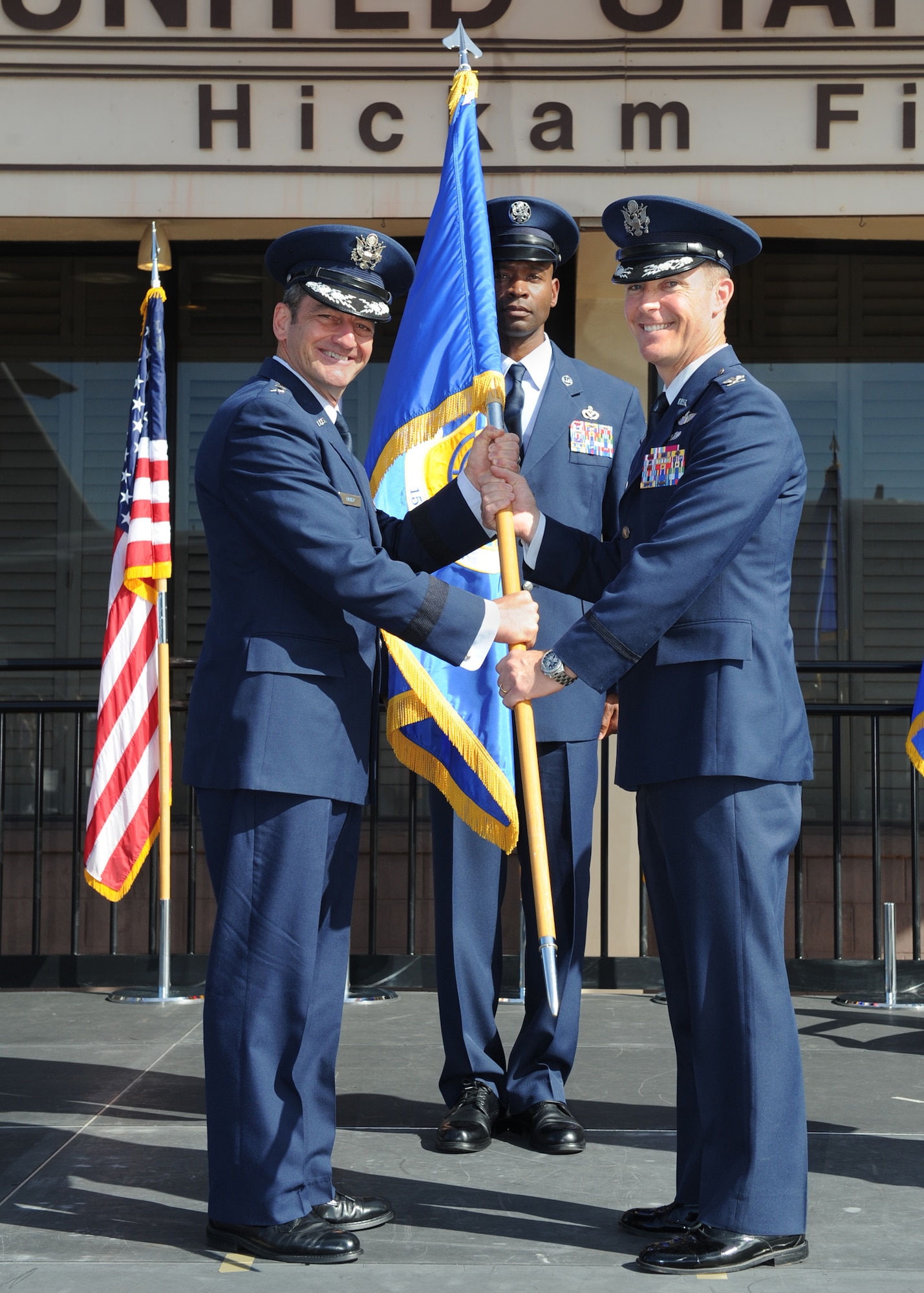 Lieutenant General Russell Handy, Pacific Air Forces commander, passes the 15th Wing guidon to Col. Kevin Gordon, 15th Wing commander, during the 15th Wing Change of Command Ceremony on Joint Base Pearl Harbor-Hickam, June 27, 2016. Gordon became the 72nd commander of the 15th Wing following the ceremony today.  (U.S. Air Force photo by Tech. Sgt. Aaron Oelrich/Released)